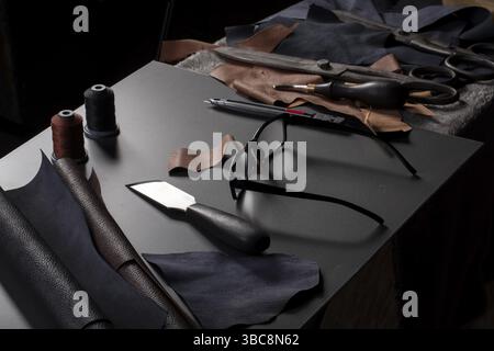 Work table with the tools of a craftsman for the production of leather goods Stock Photo