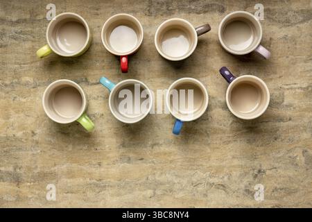 Collection of empty colorful stoneware coffee cups against textured handmade bark paper with a copy space Stock Photo