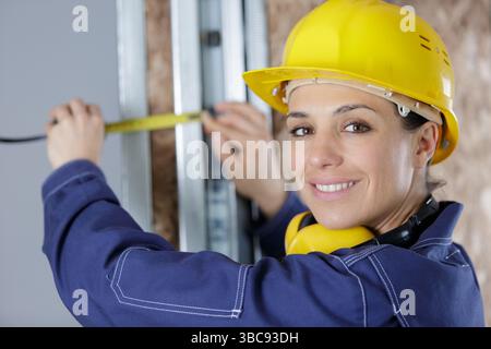 female builder using tape measure Stock Photo