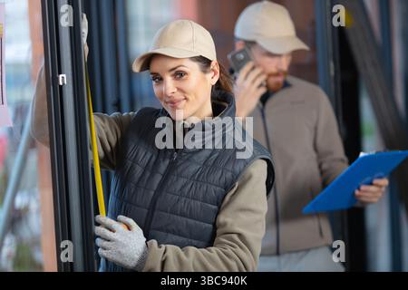 female construction worker using measuring tape Stock Photo