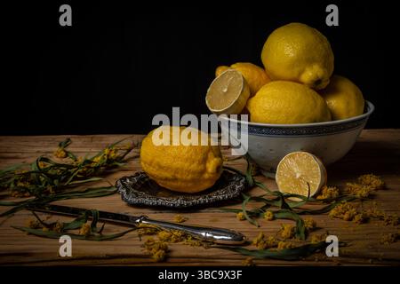 Bowl with lemons on a wooden table Stock Photo