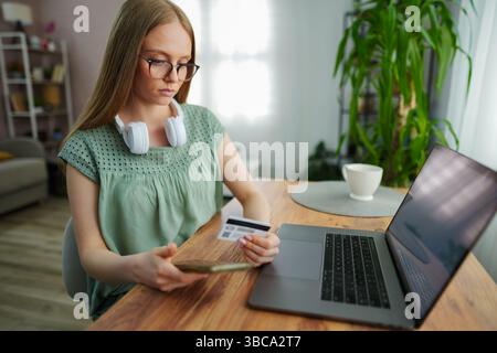 Young woman engages in online shopping at home on a quiet afternoon Stock Photo