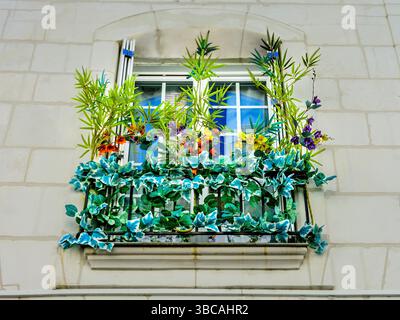 Artificial flower arrangement on upper floor window balcony - Loches, Indre-et-Loire (37), France. Stock Photo