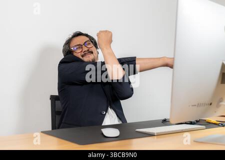 Stretching at work, essential for physical and mental well-being during long hours of desk job Stock Photo