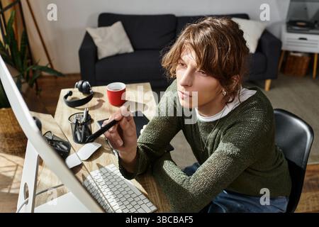 Focused young student working from home, utilizing technology and creativity to study effectively. Stock Photo