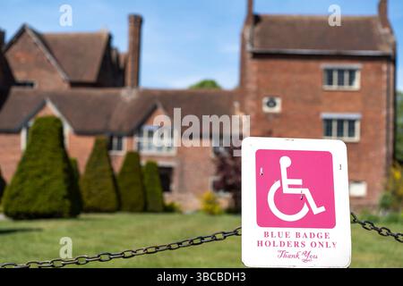 'Blue Badge Holders Only' sign in pink by private parking space at Harvington Hall, a Worcestershire tourist attraction, UK. Stock Photo