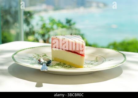 Strawberry pancakes over sea. pink and white piece of cake on the table in the restaurant against the background of the sea Stock Photo