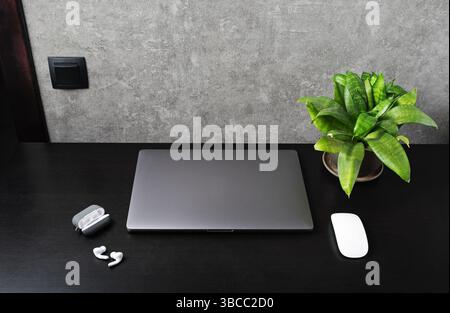 Office workspace with supplies and gadgets on black wooden table. Stock Photo