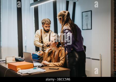 Three colleagues collaborating on a project in a modern office environment Stock Photo