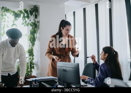 Group of business colleagues discussing during a collaborative meeting in modern office Stock Photo