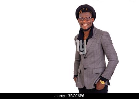 portrait of a handsome, well-dressed young businessman holding both hands in his pockets while smiling. Stock Photo