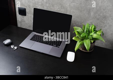 Office gadgets and laptop with blank screen. Stock Photo