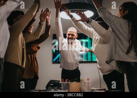 Group celebrating success together in an energetic business environment Stock Photo