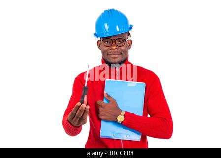 young male construction engineer holding clipboard and screwdriver while smiling. Stock Photo