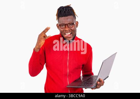 a young student with braided hair standing against white background holding laptop while showing victory gesture while smiling. Stock Photo