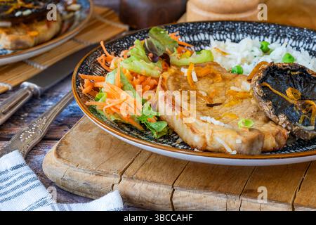 Orange glazed pork escalopes and portobello mushrooms with rice Stock Photo