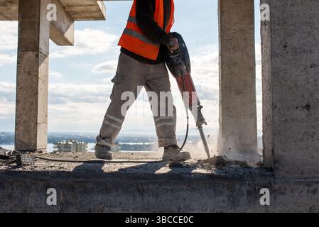 Construction worker using jackhammer to drill concrete floor. High quality photo Stock Photo