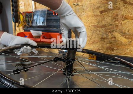 Close-up of mechanic repairing wheel Stock Photo