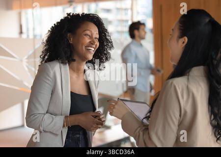 Two positive businesswomen engaged in cheerful conversation Stock Photo