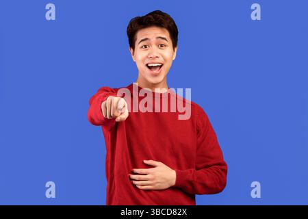 Young handsome asian man laughing at you Stock Photo