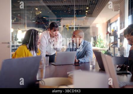 Diverse business team collaborating on project in modern office Stock Photo