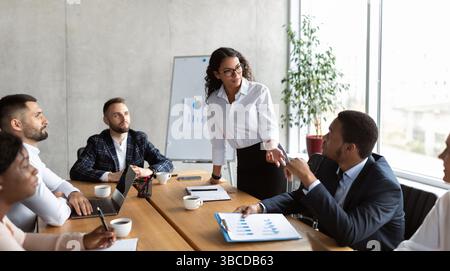 Businesswoman On Business Meeting Talking With Colleagues Standing In Office Stock Photo