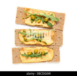 Crispbreads with tasty hummus and arugula on white background Stock Photo