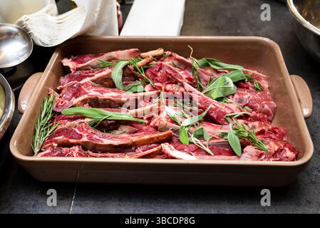 Fresh raw lamb chops arranged on rustic wooden board. Red cherry ...