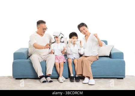 four generations (grandparents and grandchildren) playing VR games on the sofa Stock Photo