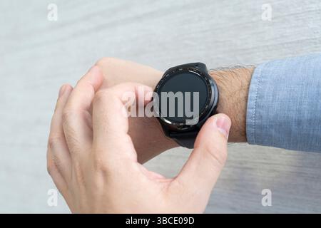 the man presses his finger on the screen on his smartwatch. top view Stock Photo