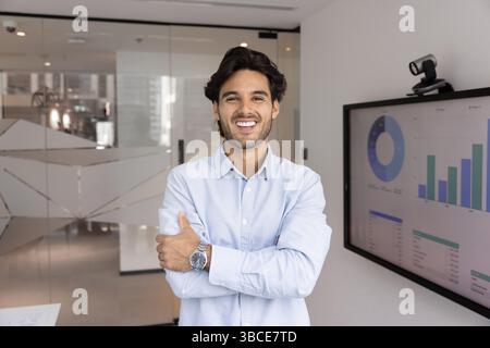 Office portrait of handsome Hispanic man posing confidently in workplace Stock Photo