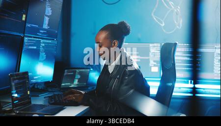 Black woman, typing and coding on computer at night for programming, cyber attack and online information. Person, pc and research for website phishing Stock Photo