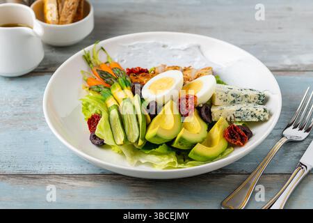 Healthy salad bowl with grilled chicken, avocado, egg, and blue cheese Stock Photo