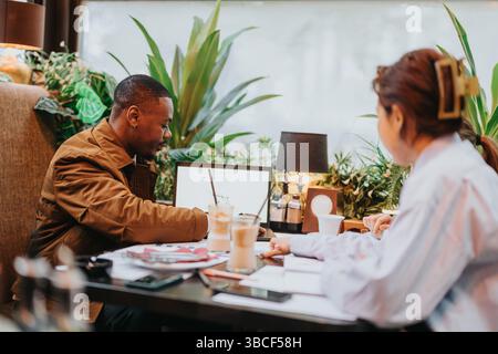 Collaborative brainstorming session between colleagues in a modern cafe setting Stock Photo