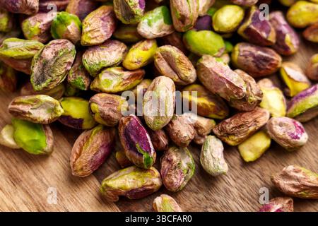 Shelled pistachio nuts on a rotating wooden surface. Stock Photo