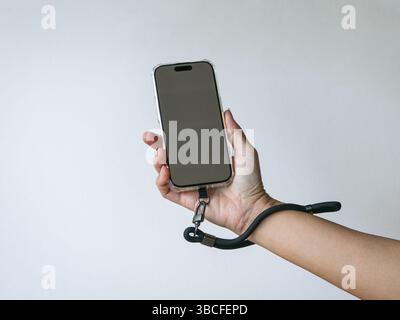 Hand holding phone with a wrist lanyard strap. Isolated on white background. Stock Photo