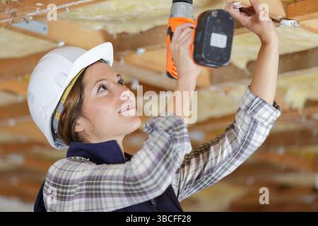 female builder using corless drill Stock Photo