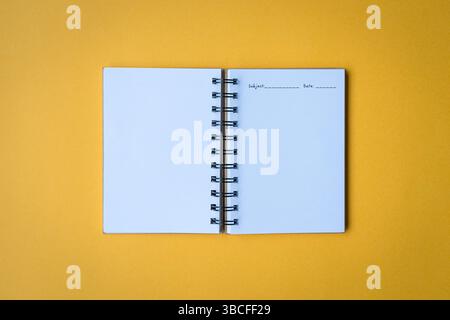Open notepad, top view. Isolated on yellow background. Stock Photo