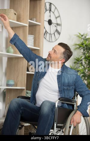male student on wheelchair reaching for a book Stock Photo