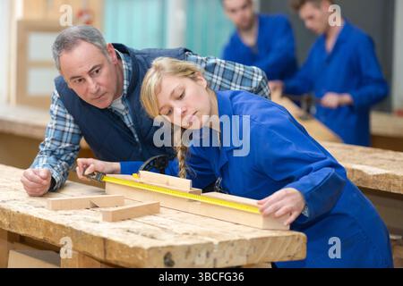 carpenter with female apprentice in workshop Stock Photo