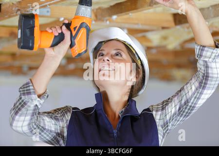 female construction worker using cordless drill Stock Photo