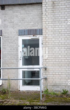 derelict concrete industrial building unit not in use with weeds growing in the cement Stock Photo