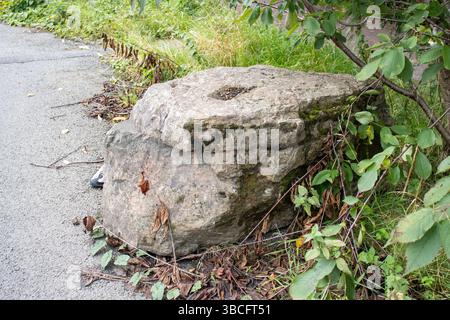 large grey boulders rocks placed next to tarmac road to security stop ...