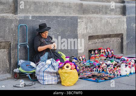 Lima, Peru - March 11, 2025: Peruvian woman selling and crafting handmade traditional Andean souvenirs. Artisanal handicrafts. Stock Photo