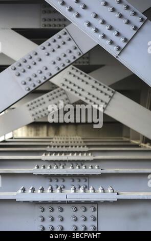 The underside of a bridge with large steel girders, bolts and nuts Stock Photo