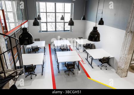 Modern workspace with multiple desks and large windows creating a bright atmosphere for collaboration Stock Photo