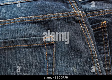 Closeup blue denim jeans with orange color thread stiching and back pocket Stock Photo