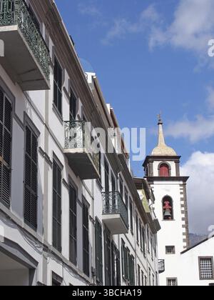 A street of old white painted houses and the tower of the historic parish church of saint peters in funchal madeira famous for being the area where cr Stock Photo