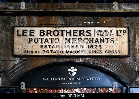 LONDON, UK - MAY 17, 2025:  Old sign in Borough Market for Lee Brothers Ltd Potato Merchants above modern sign Stock Photo