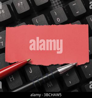 Sticker lying on black keyboard. Important message written over paper Stock Photo